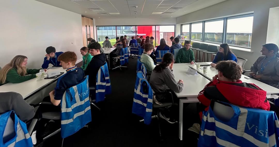 Students observing a presentation with visitor vests